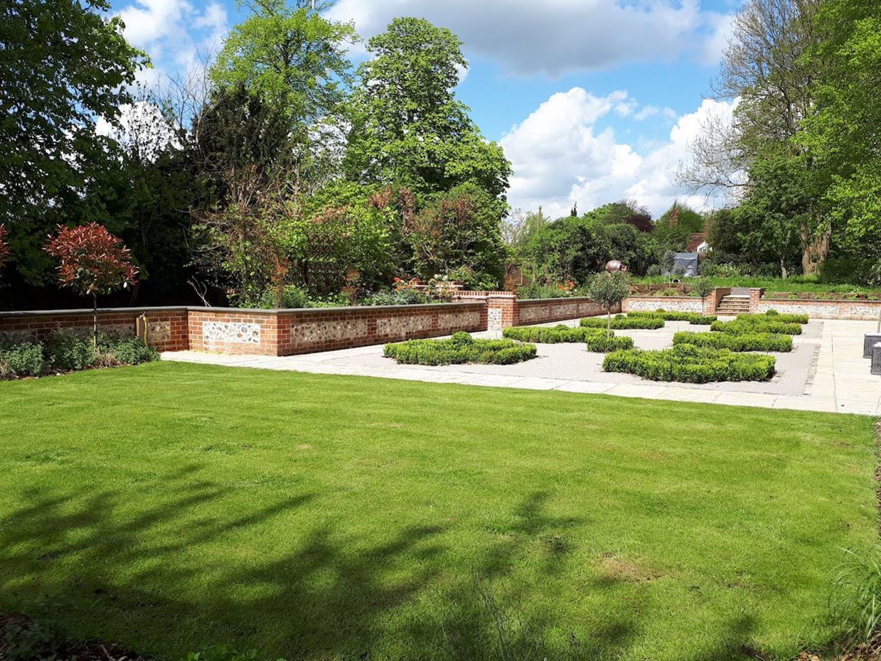 Garden design in Denham, Buckinghamshire with parterre and flint and brick walling.