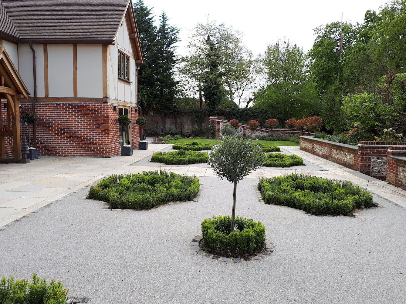 Garden design in Denham, Buckinghamshire with parterre, and flint and brick walls.