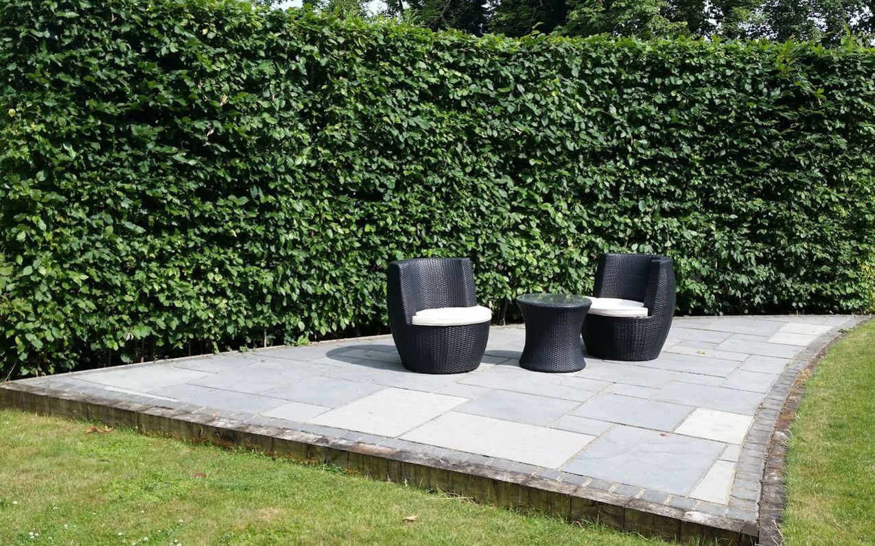 A secluded seating area in a long, narrow garden design in Woking, Surrey.