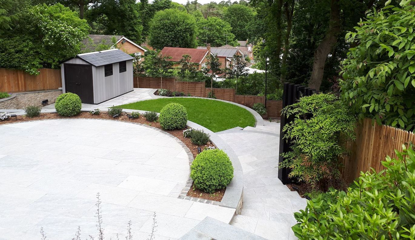 A sloping garden design in Sandhurst, Berkshire with stone faced retaining walls and terraced levels.