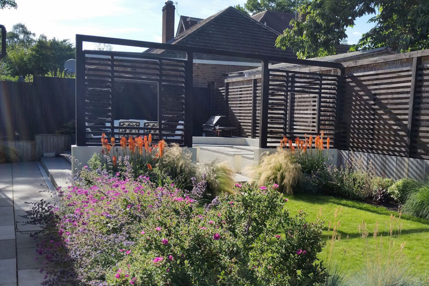 Garden design in Crowthorne, Berkshire with outdoor rooms, fireplace, pergola and terraced levels.