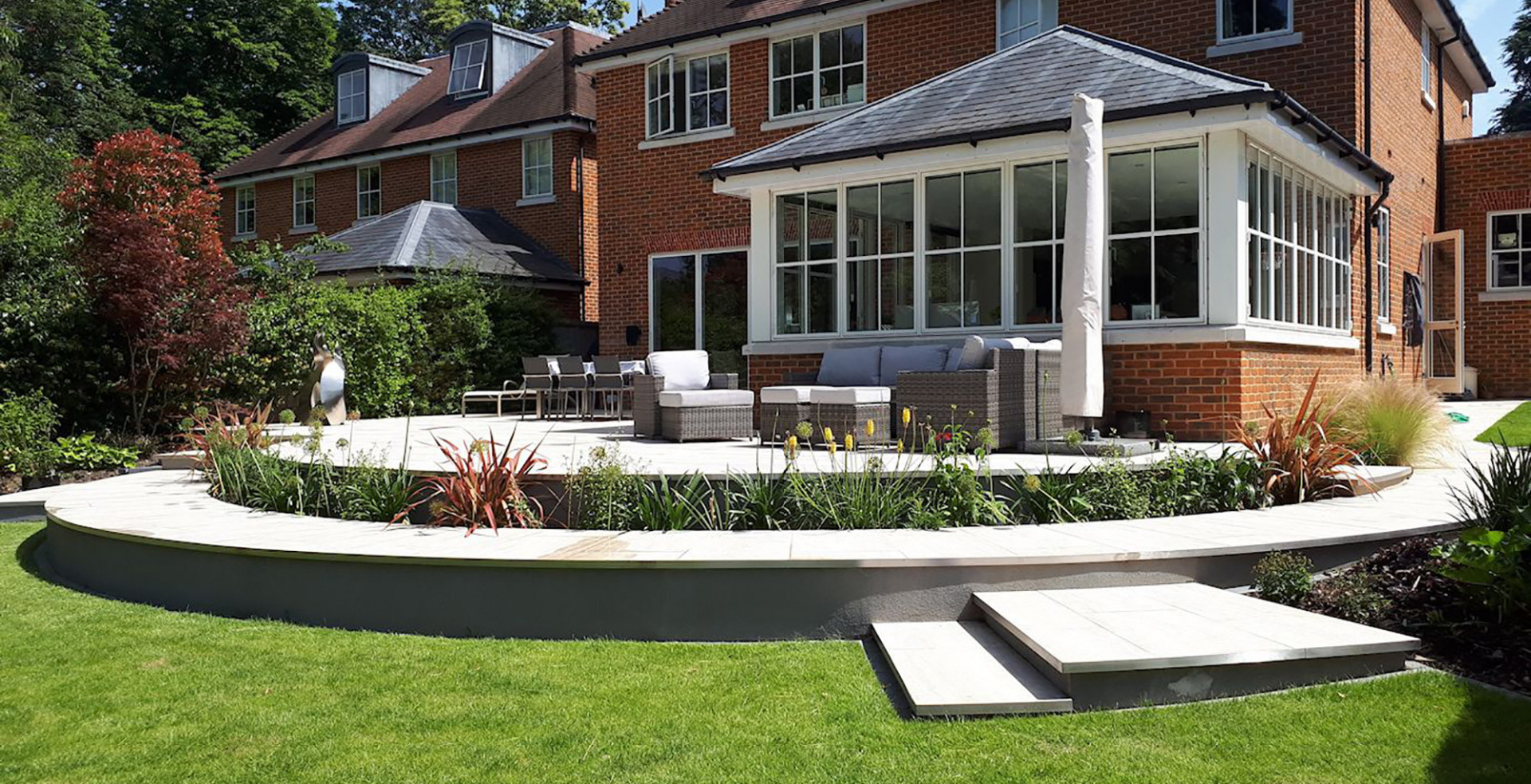 Sloping garden design with curved patio in Esher, Surrey.